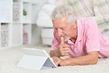 Fototapeta premium Portrait of beautiful senior man using tablet at home