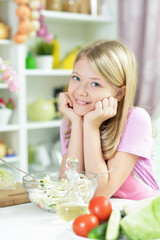 Portrait of cute little girl preparing fresh salad
