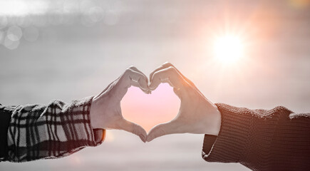 Mann und Frau bilden ein Herz mit den Händen