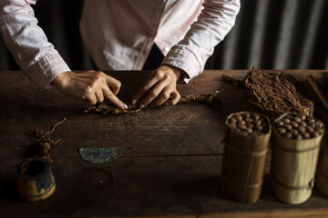 Hands of a woman rolling a cuban cigar in a beautfiul ambient. Vinales, Cuba