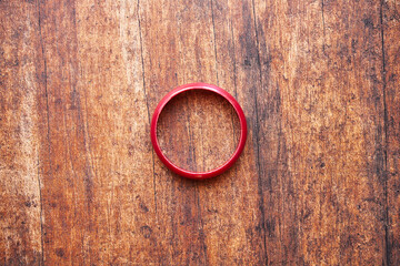 czerwona bransoletka na drewnianym stole 