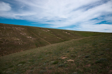 Beautiful mountain landscape. Journey in the spring. Green meadows against the blue sky.