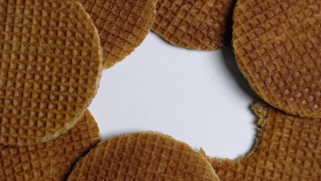 Abstract shot with white space - stroopwafels with bite out of it.