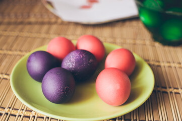 Obraz na płótnie Canvas Bright multicolored painted Easter eggs on green ceramic plate