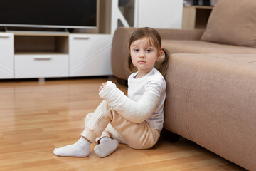 A little girl with a broken arm and a cast