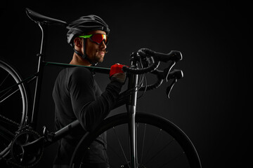 male cyclist with road bicycle on black background - obrazy, fototapety, plakaty