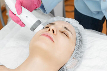 Obraz na płótnie Canvas Radio wave face lifting in a cosmetology clinic photo. Skin treatment. Hardware cosmetology.