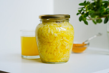 Fermented cabbage with turmeric. Cabbage kvass. Pickling vegetables without salt. Fermentation. Vitamin treatment and nutrition. Organic turmeric powder and green leaves of houseplant in a frame.