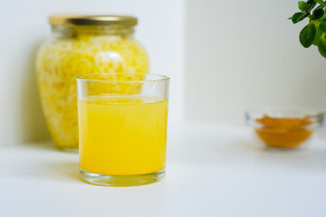 Fermented cabbage with turmeric. Cabbage kvass. Pickling vegetables without salt. Fermentation. Vitamin treatment and nutrition. Organic turmeric powder and green leaves of houseplant in a frame.