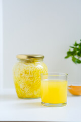 Fermented cabbage with turmeric. Cabbage kvass. Pickling vegetables without salt. Fermentation. Vitamin treatment and nutrition. Organic turmeric powder and green leaves of houseplant in a frame.