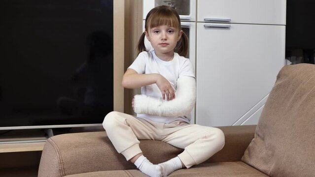 A sweet sad little girl with a broken arm in a cast