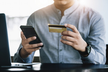 Online Shopping and Internet Payments, Asian man are using their credit card and mobile phone to shop online or conduct errands in the digital world.