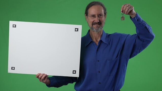 Real estate agent holding sold blank empty white sign and holding icon house key ring on green screen chroma key background.