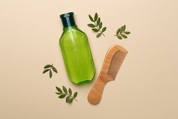 Shampoo with herbal extract and comb on color background, top view