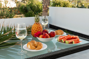 Tasty breakfast on glass table juice fruits with palm on background