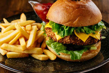 beef burger on a plate with potatoes and sauce
