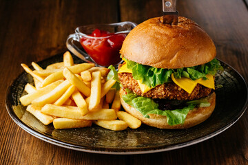 beef burger on a plate with potatoes and sauce