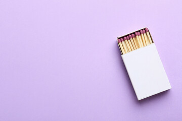 Box with matchsticks on color background