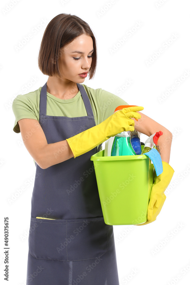 Wall mural Beautiful young woman with cleaning supplies on white background