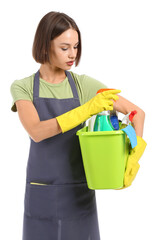 Beautiful young woman with cleaning supplies on white background