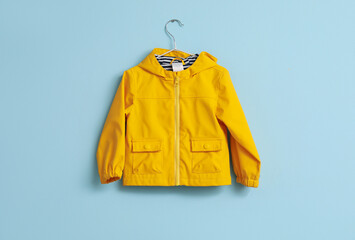 Child's raincoat hanging on blue wall