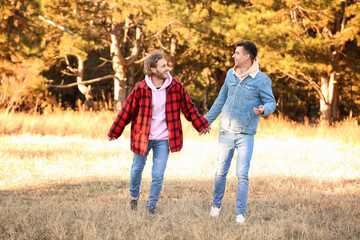 Fototapeta premium Happy gay couple walking outdoors on autumn day