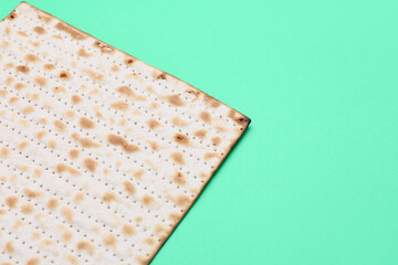 Jewish flatbread matza for Passover on green background, closeup