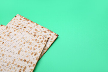 Jewish flatbread matza for Passover on green background, closeup
