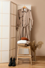 Obraz na płótnie Canvas Step stool with stack of warm clothes, boots and vase in hall