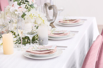 Stylish table setting with wedding invitations and gypsophila flowers