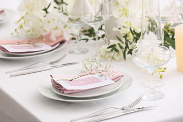 Stylish table setting with wedding invitations and gypsophila flowers