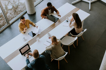 Aerial view at group of multiethnic business people working together and preparing new project on a...