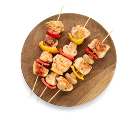 Wooden board of grilled chicken skewers with vegetables isolated on white background
