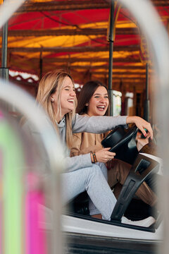 Two young women having fun while they are driving a bumper car