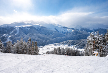 Beautiful landscape of the Arkhyz ski resort with mountains, snow, forest and track on a sunny winter day. Caucasus  Mountains, Russia