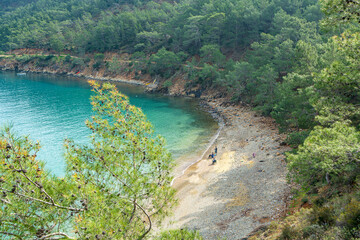 Fototapeta na wymiar The Bay of Adrasan extends along more than 2.5 km of Antalya, naturally protected area, surrounded by a national park with pine forests, Taurus Mountains, blue water lagoons and sandy beaches.