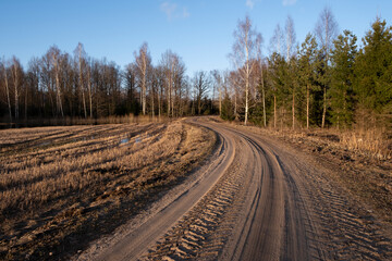 tractor or heavy truck and car tire prints in sand and gravel dirt road