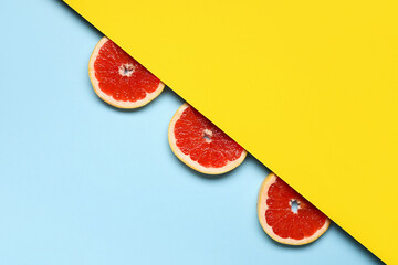 Slices of tasty ripe grapefruit on color background