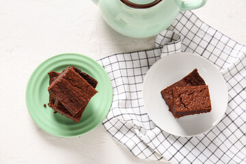 Plates with pieces of delicious chocolate brownie on light background