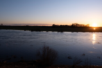 clear sky, golden sunset, winding river, purple clouds, spring evening near Lielupe river Latvia