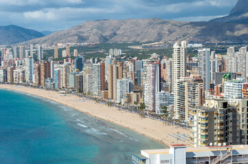 A view of the coast in Benidorm with tall buildings, mountains and sea