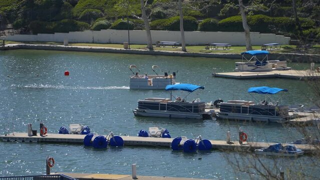 Pontoon boat approaching dock on Lake Mission Viejo, California. Slowed to quarter speed