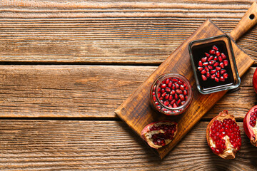 Bowl and jar of pomegranate molasses on wooden background