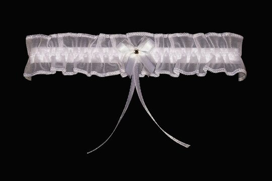 Women's wedding white garter on a black background.