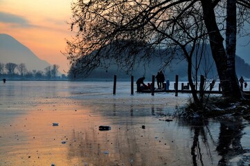 Frozen Alpine Lake Lago di Piano in Dusk with Mountain and Tree in Lombardy, Italy.