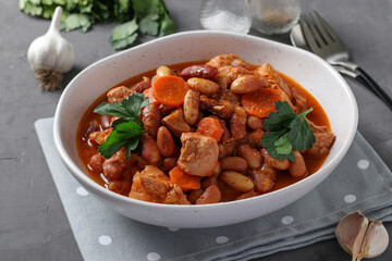 Turkey fillet with beans and carrots, cooked in tomato sauce, served in a white plate, Healthy diet