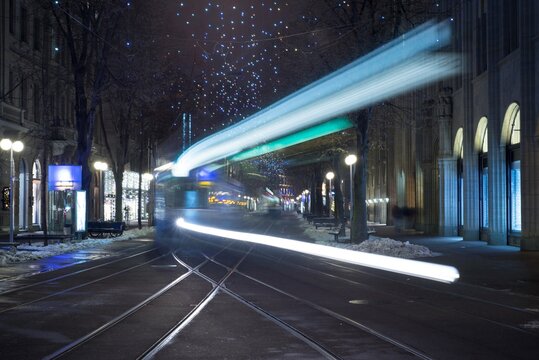 Fototapeta City Tram at Night with Light Trails in Long Exposure in Bahnhofstrasse in Zurich, Switzerland.
