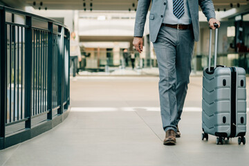 Obraz premium Close Up Photo of Business Man Legs Walking With Luggage in the Airport