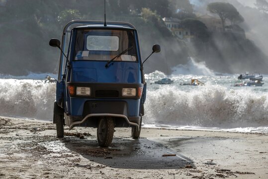 Italian Car Ape on the Sand Beach with Wave in Sestri Levante in Liguria, Italy.