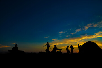 Fototapeta na wymiar 夕暮れの丘と人々のシルエット